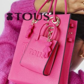 Imagem de uma mala e uma carteira da Tous no mesmo tom Rosa, pink, lilas 